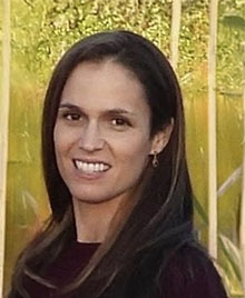 The image shows a woman posing outdoors.